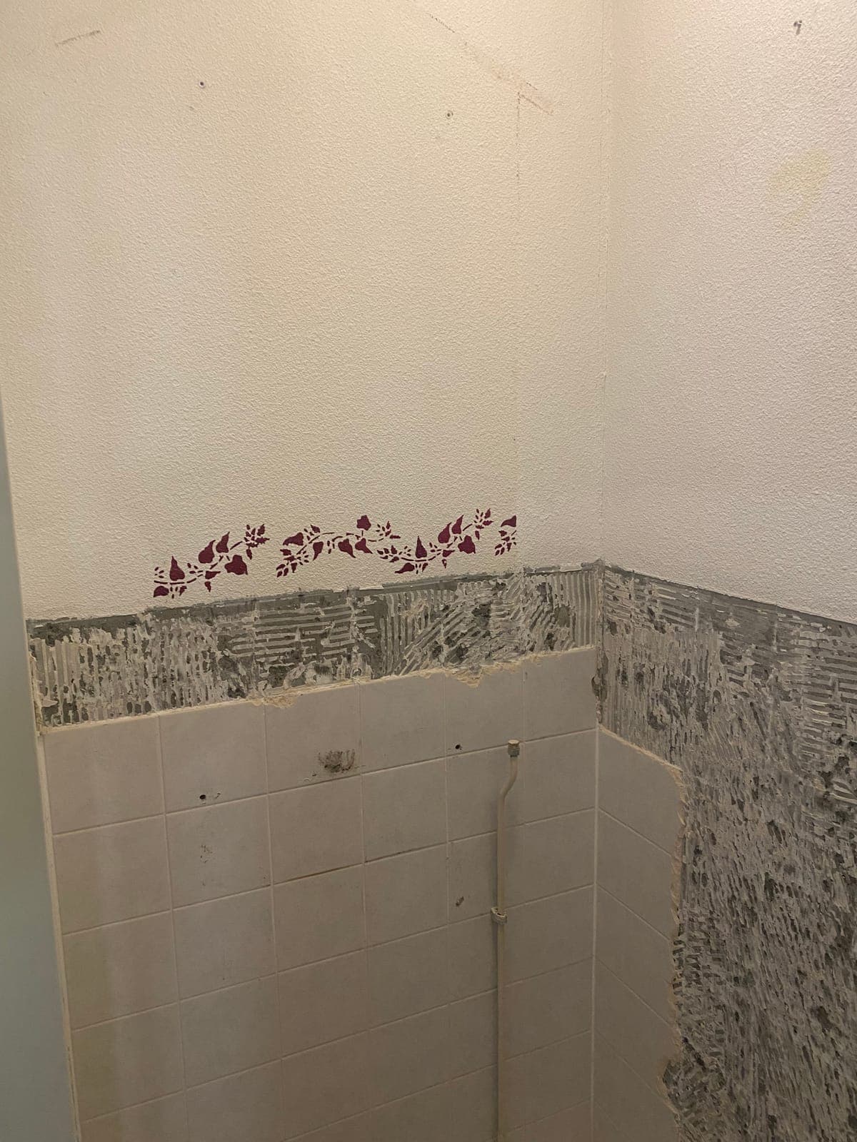 Het toilet vóór de renovatie, met verwijderde tegels en zichtbare schade